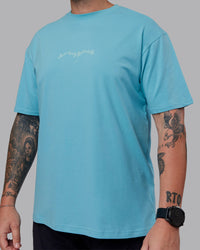 Man wearing Just Run FLXCotton Oversized Tee - Retro Blue-Light Retro Blue | Model:Macca | Size:M