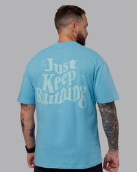 Man wearing Just Run FLXCotton Oversized Tee - Retro Blue-Light Retro Blue | Model:Macca | Size:M
