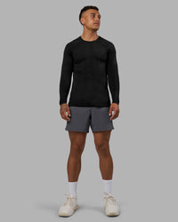 Man wearing AeroFLX+ Seamless Long Sleeve Tee - Black Marl | Model:Daarian | Size:M