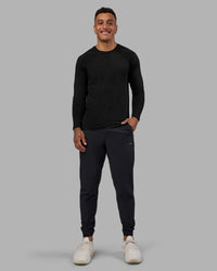 Man wearing AeroFLX+ Seamless Long Sleeve Tee - Black Marl | Model:Daarian | Size:M