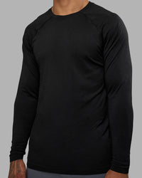 Man wearing AeroFLX+ Seamless Long Sleeve Tee - Black Marl | Model:Daarian | Size:M