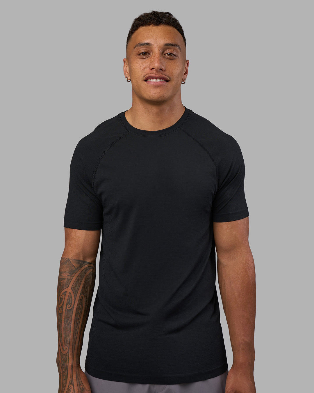 Man wearing AeroFLX+ Seamless Tee - Black Marl | Model:Daarian | Size:M
