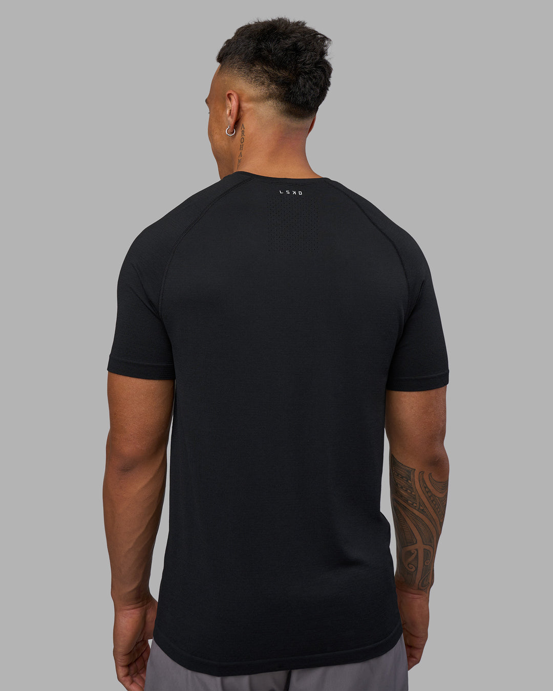 Man wearing AeroFLX+ Seamless Tee - Black Marl | Model:Daarian | Size:M