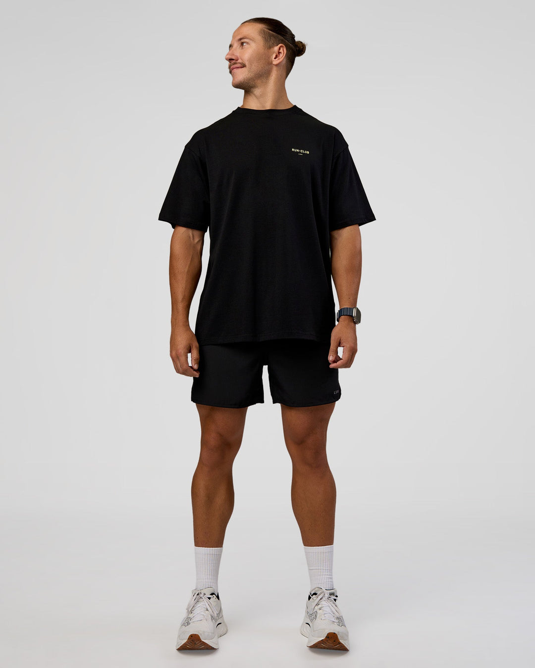 Man wearing RUN CLUB FLXCotton Tee Oversize - Black-Yellow Fizz | Model:Jaiden | Size:M