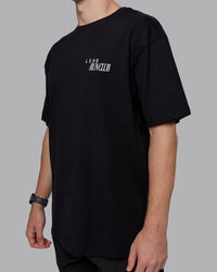 Man wearing Run Love FLXCotton Oversized Tee - Black-Reflective | Model:Cameron | Size:M