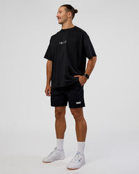 Man wearing Trust The Process Heavyweight Unisex Oversized Tee - Black-White | Model:Jaiden | Size:M