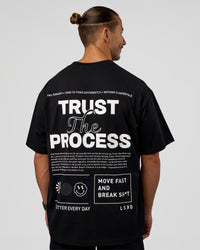 Man wearing Trust The Process Heavyweight Unisex Oversized Tee - Black-White | Model:Jaiden | Size:M