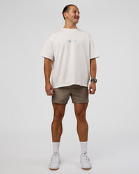 Man wearing Trust The Process Heavyweight Unisex Oversized Tee - Off White-Electric Indigo | Model:Jaiden | Size:M