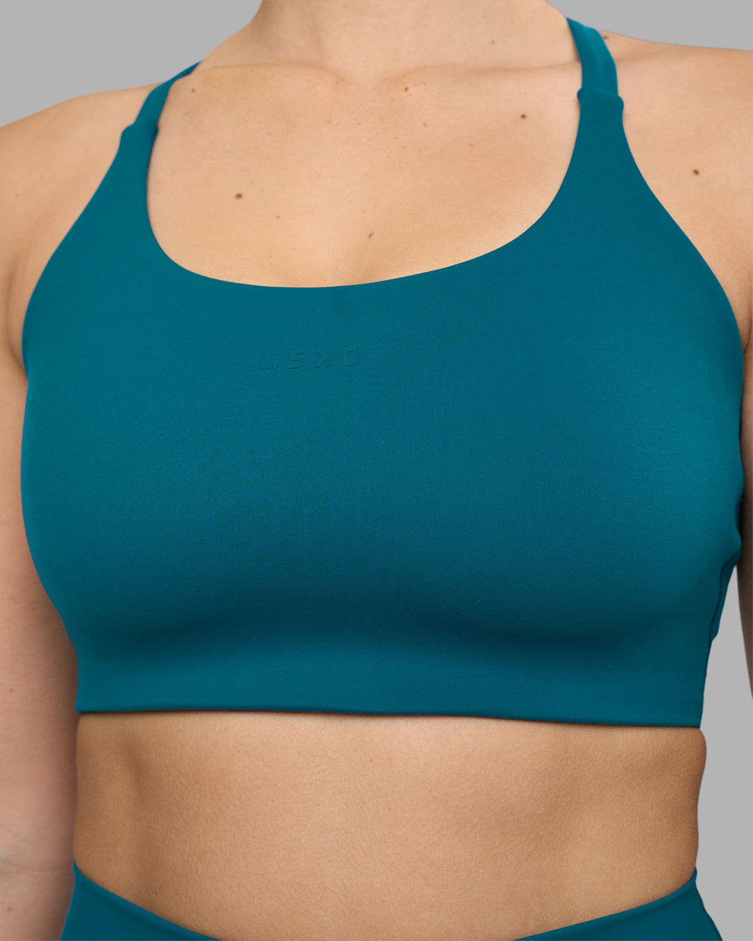 Woman wearing Twist Sports Bra D/DD/E - Blue Coral | Model:Amy | Size:M