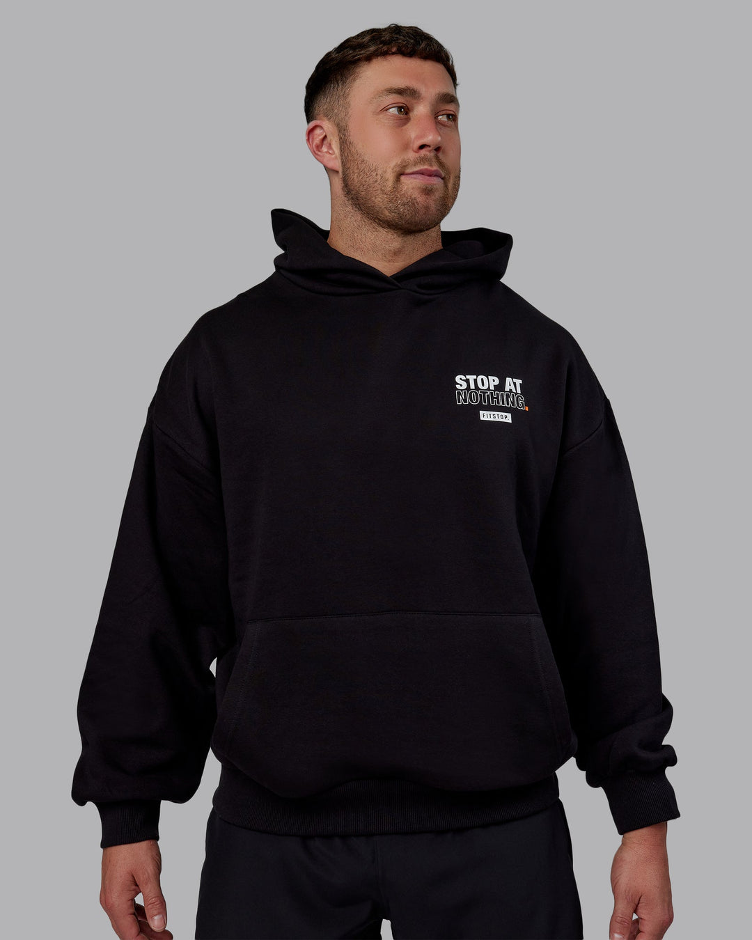 Man wearing Unisex Fitstop Stop at Nothing Hoodie Oversize - Black