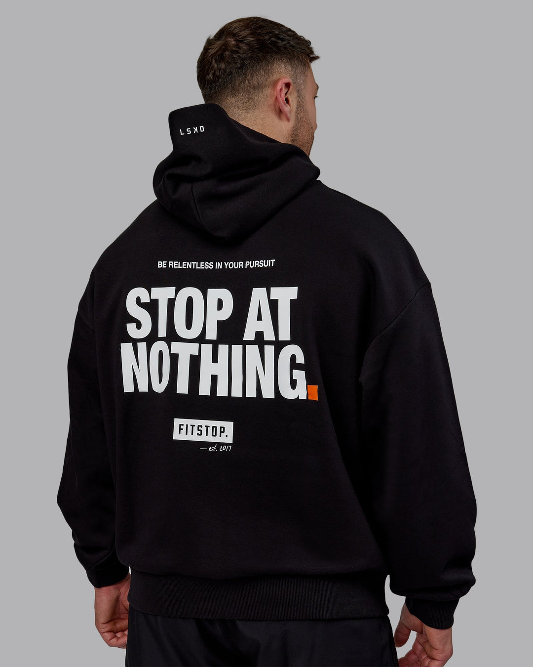 Man wearing Unisex Fitstop Stop at Nothing Hoodie Oversize - Black