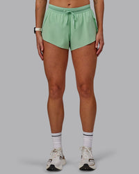 Woman wearing Accelerate 3" Run Shorts - Surreal Green | Set:true | Angle:front 