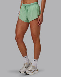 Woman wearing Accelerate 3" Run Shorts - Surreal Green | Set:true | Angle:side 
