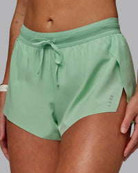 Woman wearing Accelerate 3" Run Shorts - Surreal Green | Set:true | Angle:closeup 
