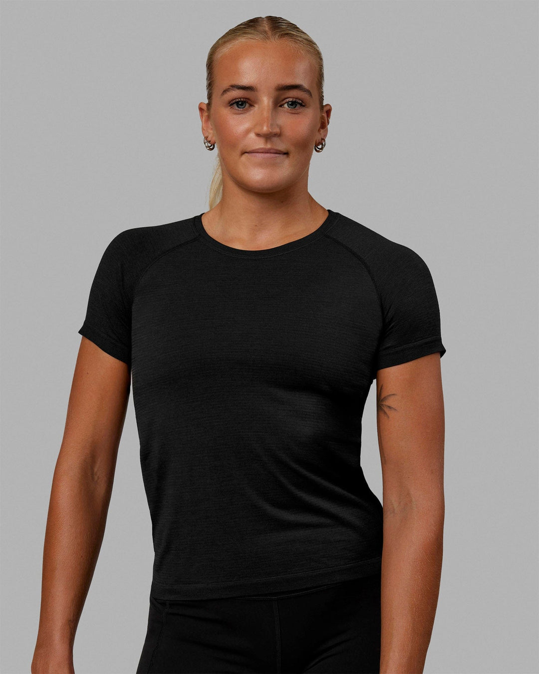 Woman wearing AeroFLX+ Seamless Tee - Black Marl