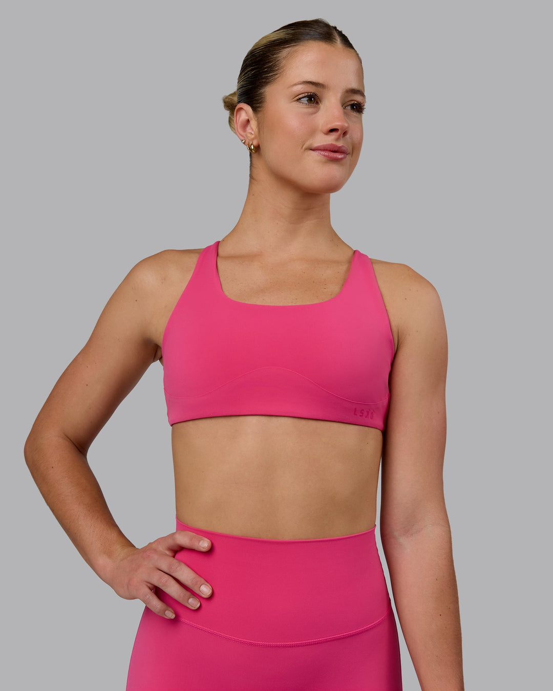 Woman wearing Aspire Sports Bra - Pink Flash