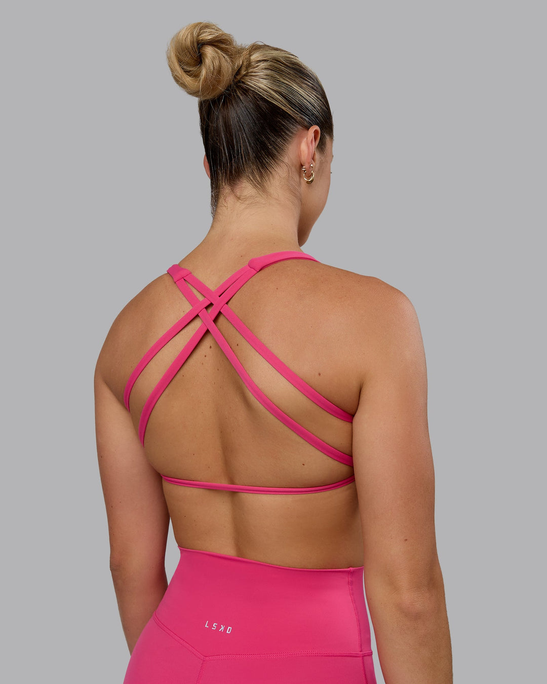 Woman wearing Aspire Sports Bra - Pink Flash