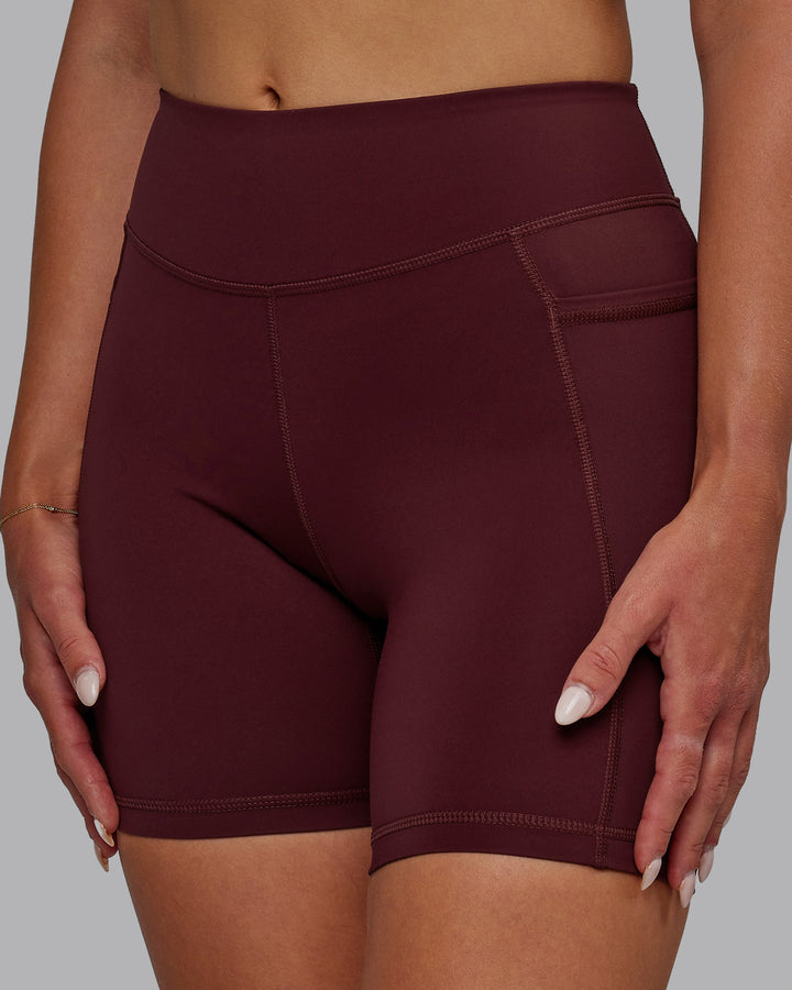 Woman wearing Elite Mid-Length Shorts - Dark Cherry
