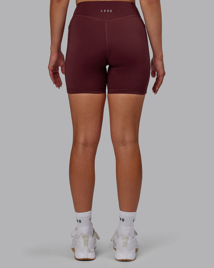 Woman wearing Elite Mid-Length Shorts - Dark Cherry
