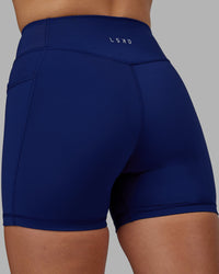 Woman wearing Elite High-Rise 4" Short Pockets - Midnight Blue