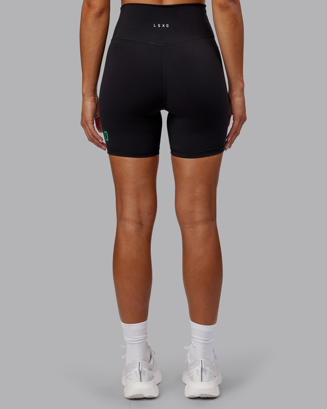 Woman wearing Evolved Mid-Length Shorts - Black-Impact Green