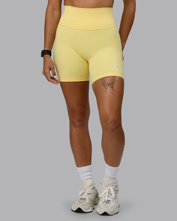 Woman wearing Evolved Mid Short Tights - Lemon-White
