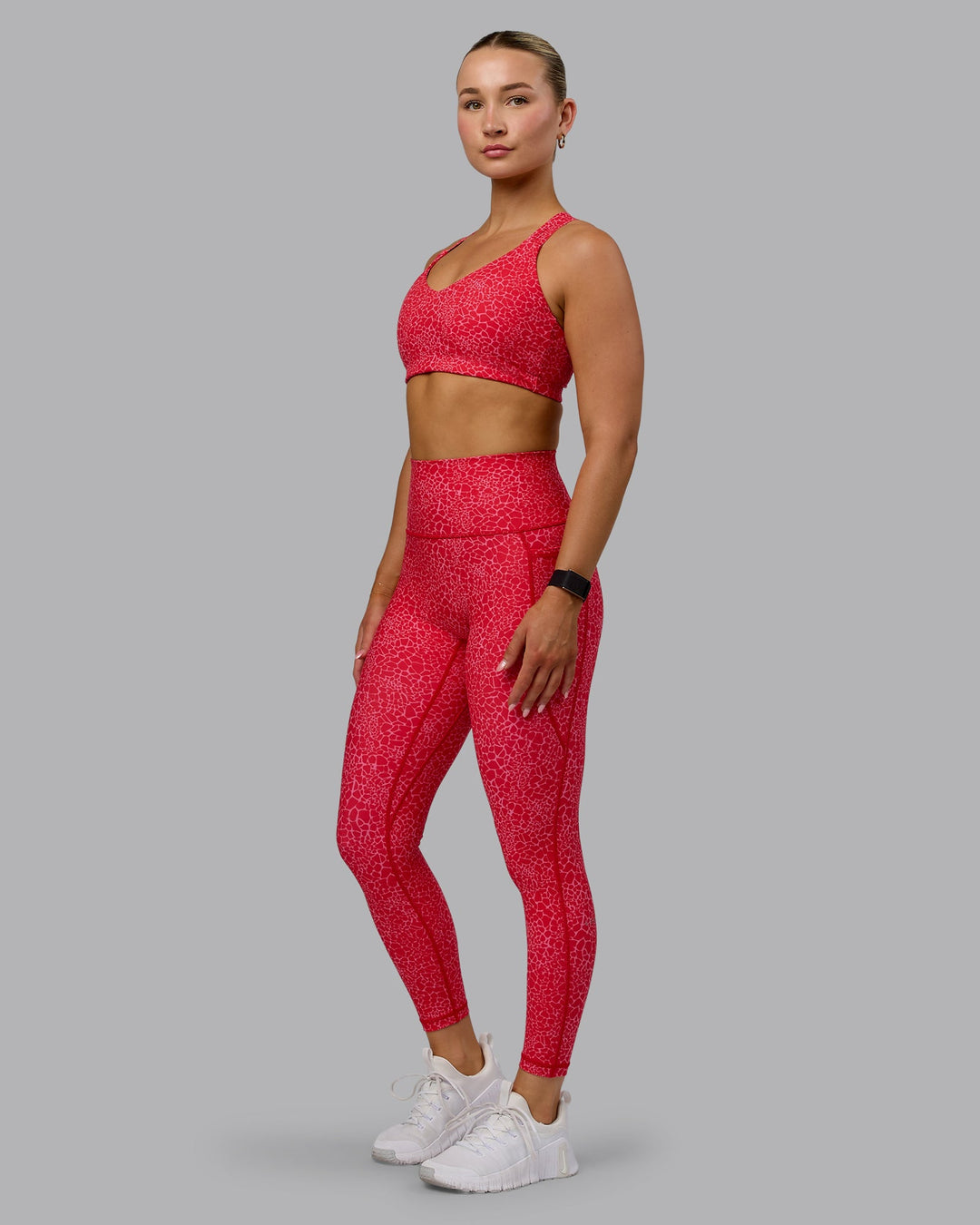Woman wearing Fusion Ultra High-Rise 7/8 Legging Pockets - Red Vitality Print | Model:Halle | Size:S