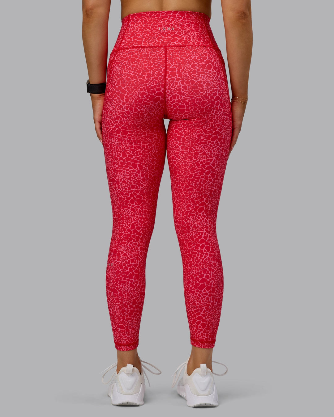 Woman wearing Fusion Ultra High-Rise 7/8 Legging Pockets - Red Vitality Print | Model:Halle | Size:S