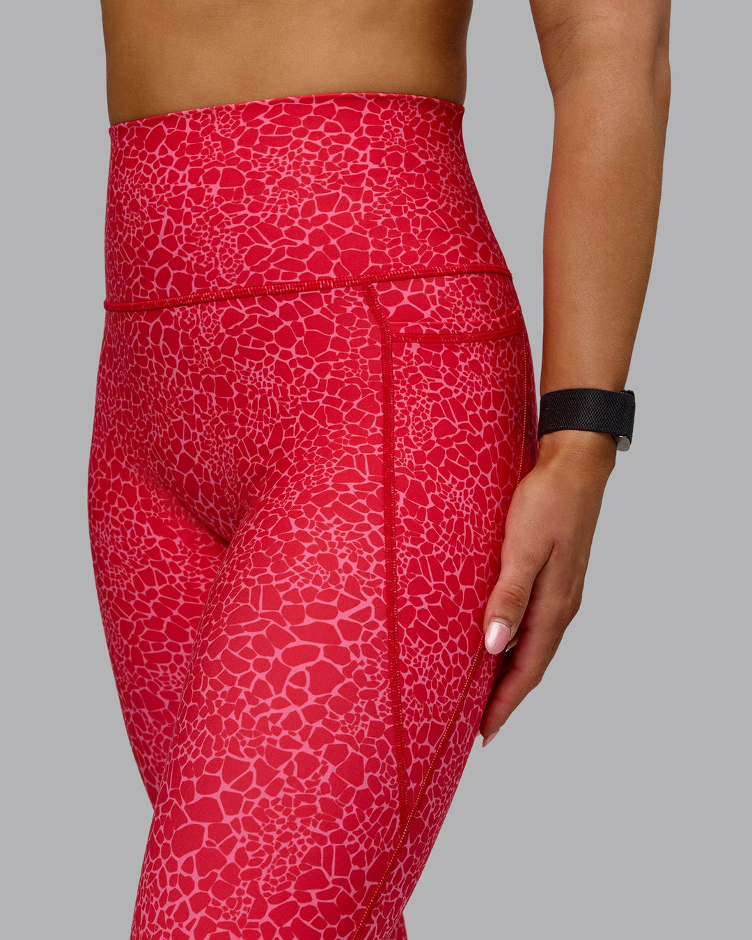 Woman wearing Fusion Ultra High-Rise 7/8 Legging Pockets - Red Vitality Print | Model:Halle | Size:S