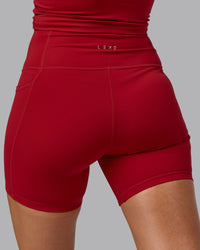 Woman wearing Fusion Ultra High-Rise 6" Short Pockets - Cherry Red | Model:Sophie | Size:S