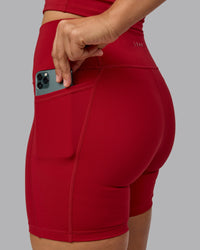 Woman wearing Fusion Ultra High-Rise 6" Short Pockets - Cherry Red | Model:Sophie | Size:S