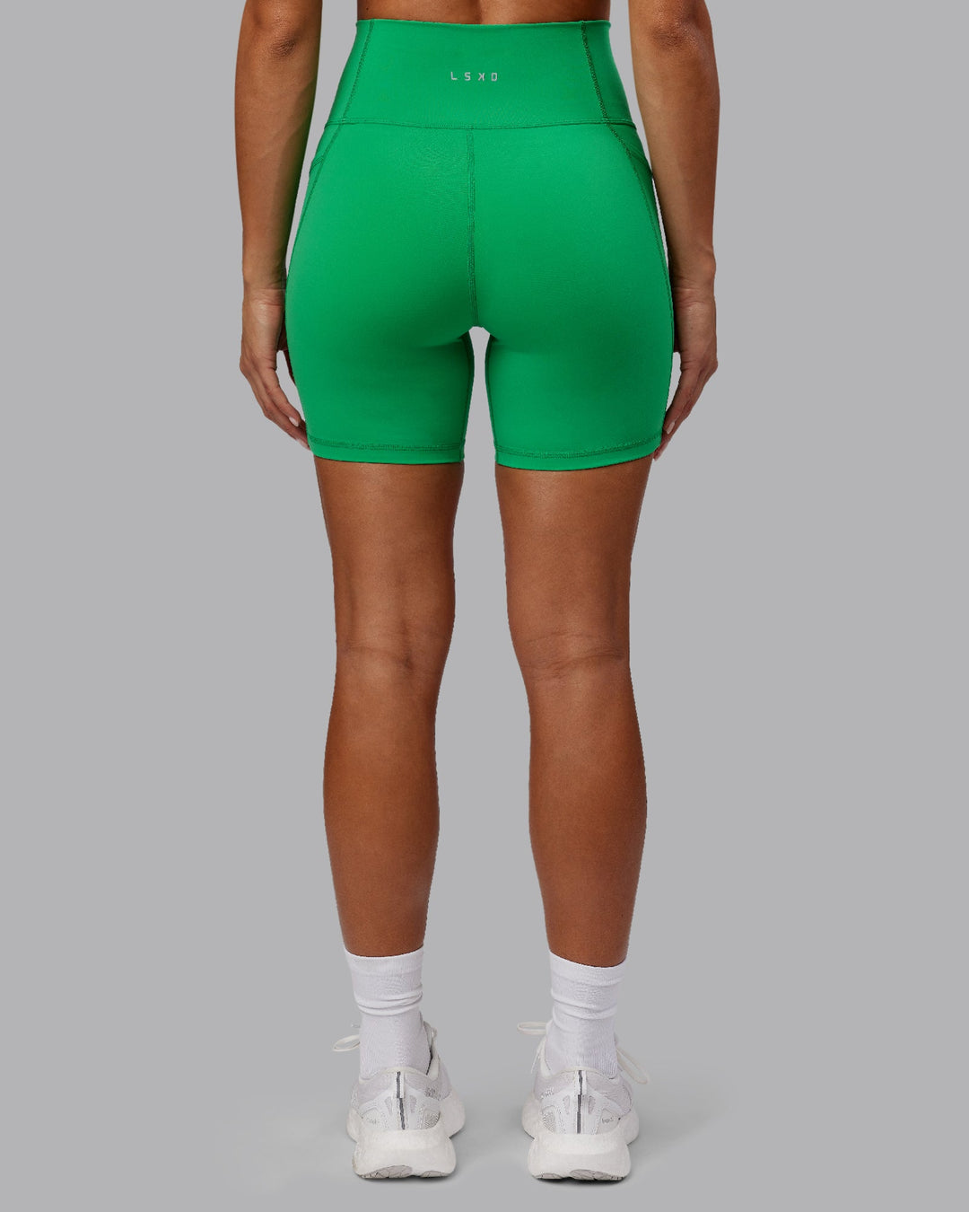 Woman wearing Fusion Ultra High-Rise 6&quot; Short Pockets - Impact Green | Model:Demi | Size:S