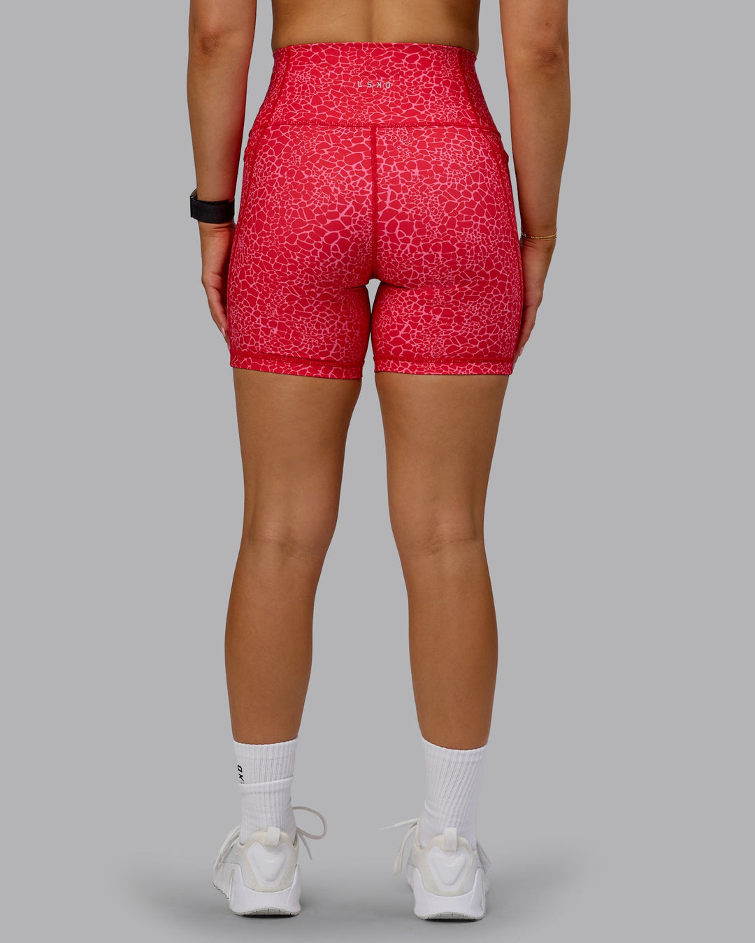 Woman wearing Fusion Ultra High-Rise 6&quot; Short Pockets - Red Vitality Print | Model:Halle | Size:S