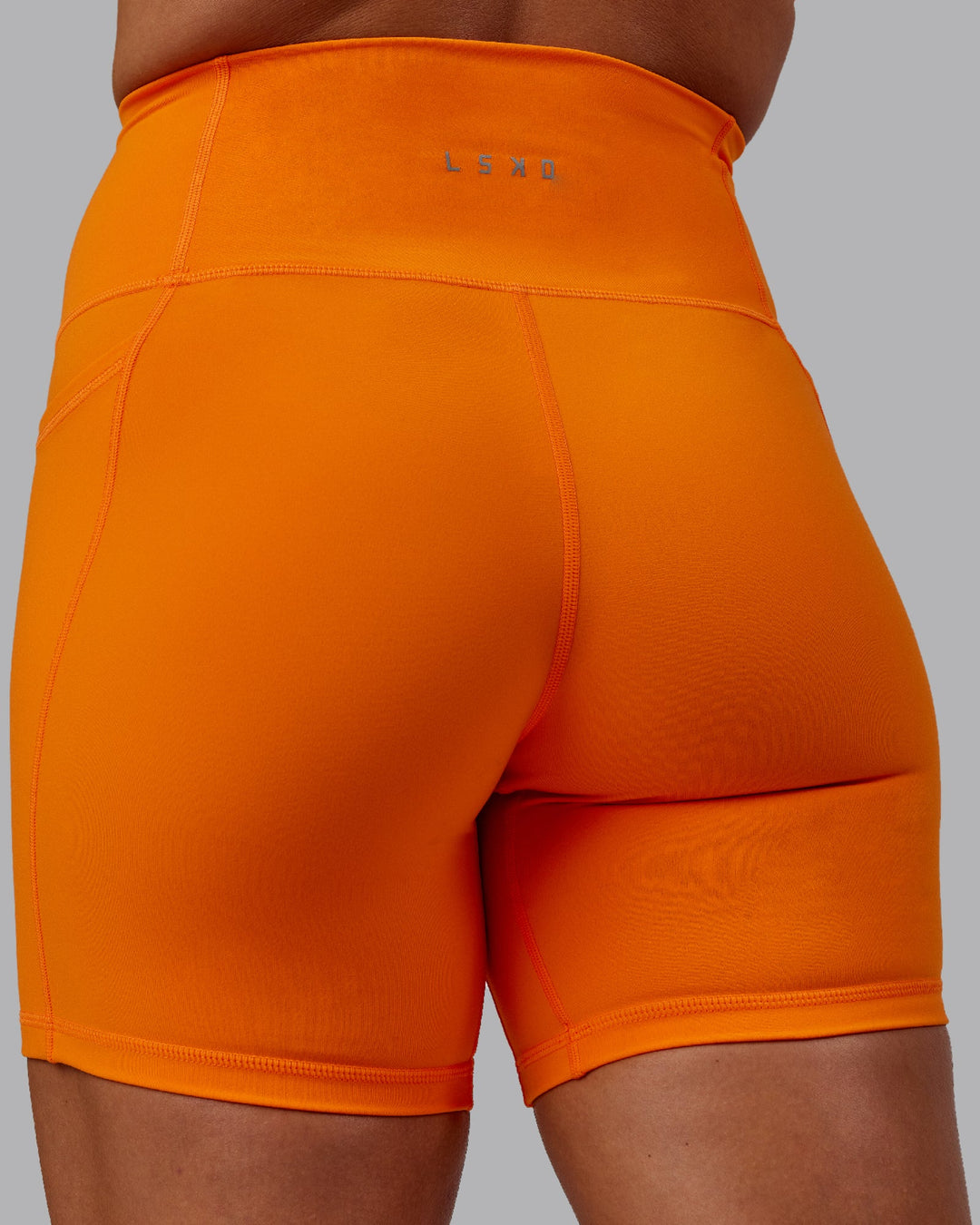 Woman wearing Fusion Ultra High-Rise 6&quot; Short Pockets - Vibrant Orange | Model:Bree | Size:S