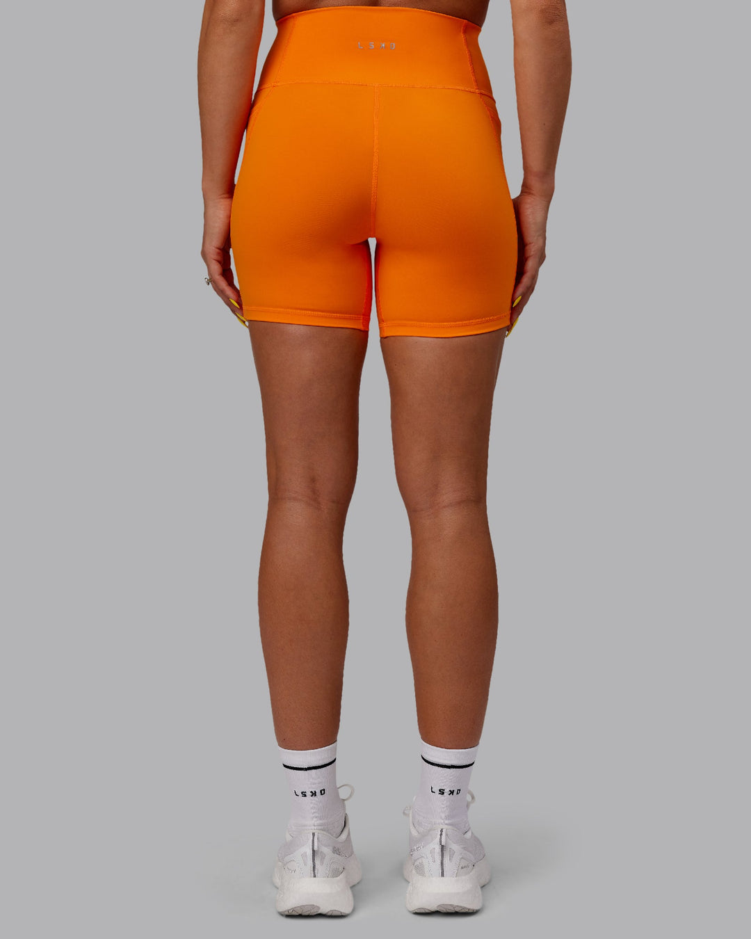 Woman wearing Fusion Ultra High-Rise 6&quot; Short Pockets - Vibrant Orange | Model:Bree | Size:S