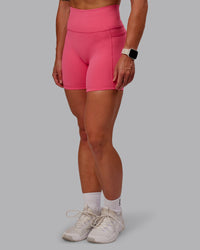 Woman wearing Fusion Ultra High-Rise 6" Short Pockets - Hot Pink | Set:true | Angle:side | Model:Amber | Size:S