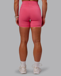 Woman wearing Fusion Ultra High-Rise 6" Short Pockets - Hot Pink | Set:true | Angle:back | Model:Amber | Size:S