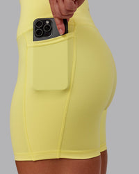 Woman wearing Fusion Ultra High-Rise 6" Short Pockets - Lemon Fizz | Set:true | Angle:closeup | Model:Amber | Size:S