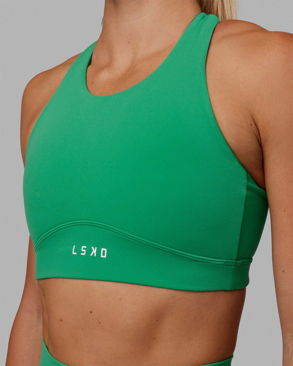 Woman wearing Fusion Sports Bra - Holly Green