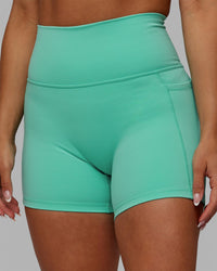 Woman wearing Fusion Ultra High-Rise 4" Short Pockets - Aquatic Awe | Model:Gabby | Size:S