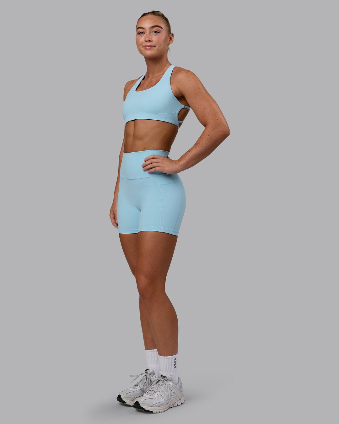 Woman wearing Fusion Ultra High-Rise 4&quot; Short Pockets - Glacial Blue | Model:Monique | Size:S