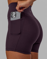 Woman wearing Fusion Ultra High-Rise 4" Short Pockets - Midnight Plum | Model:Gabby | Size:S