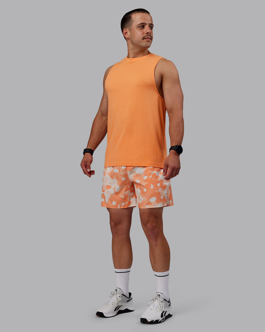 Man wearing AeroFLX+ Seamless Muscle Tank - Cantaloupe/Cantaloupe Marl