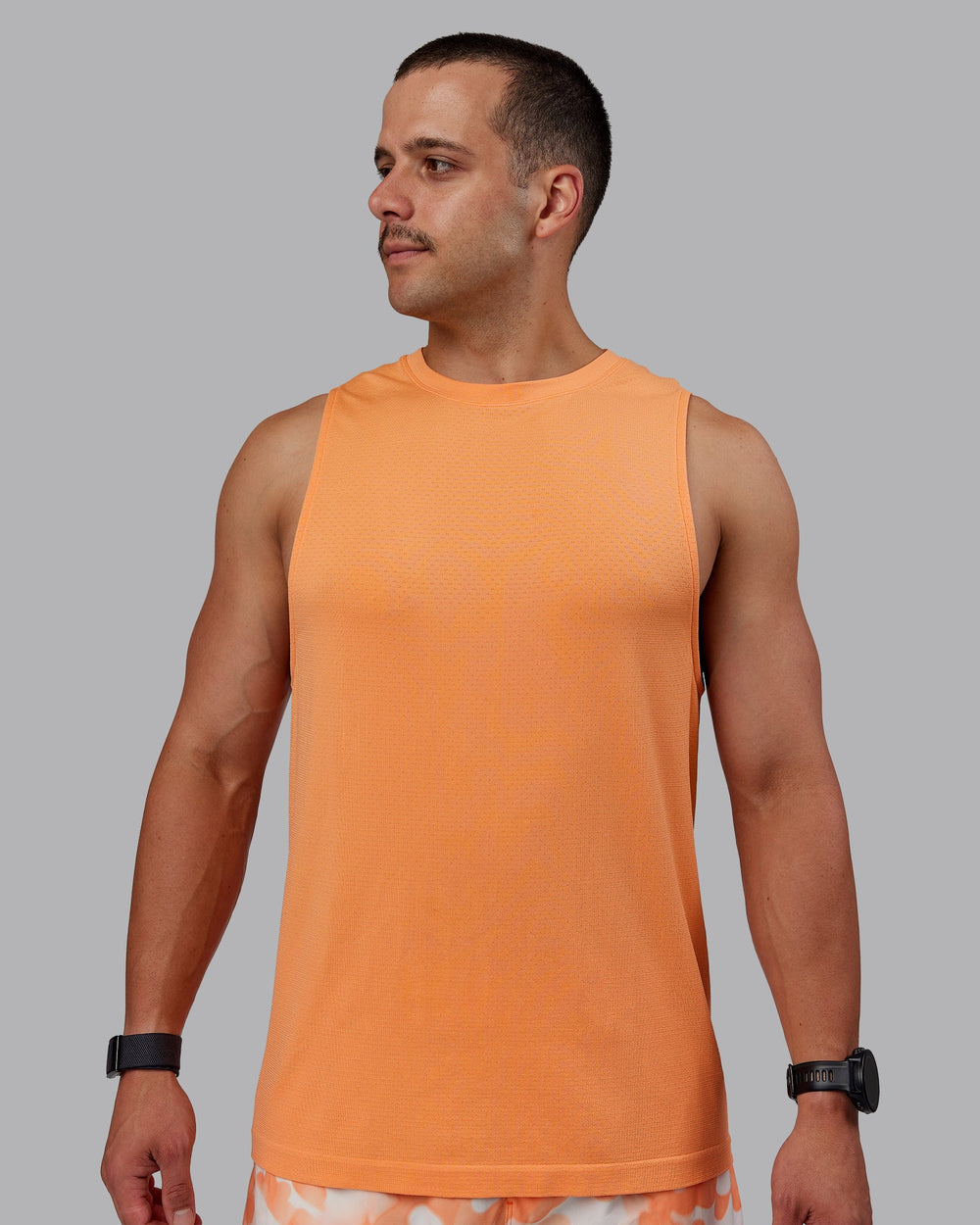 Man wearing AeroFLX+ Seamless Muscle Tank - Cantaloupe/Cantaloupe Marl