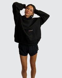 Woman wearing Oversized Apres Run Club MVP Hoodie - Black | Model:Meg | Size:XS