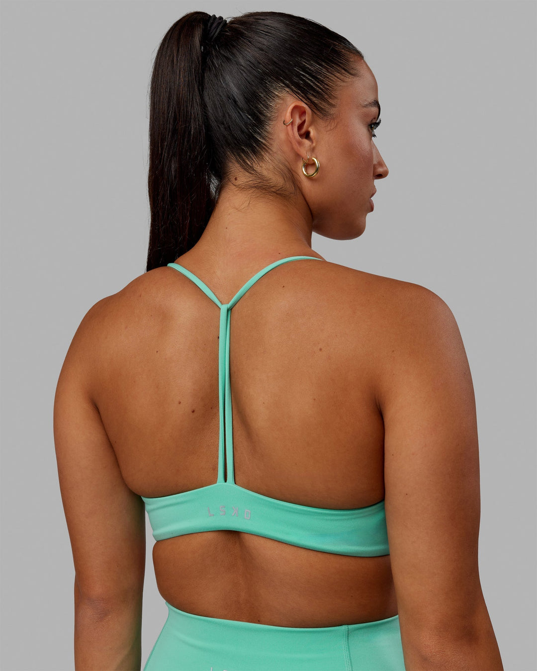 Woman wearing Progression Sports Bra - Aquatic Awe