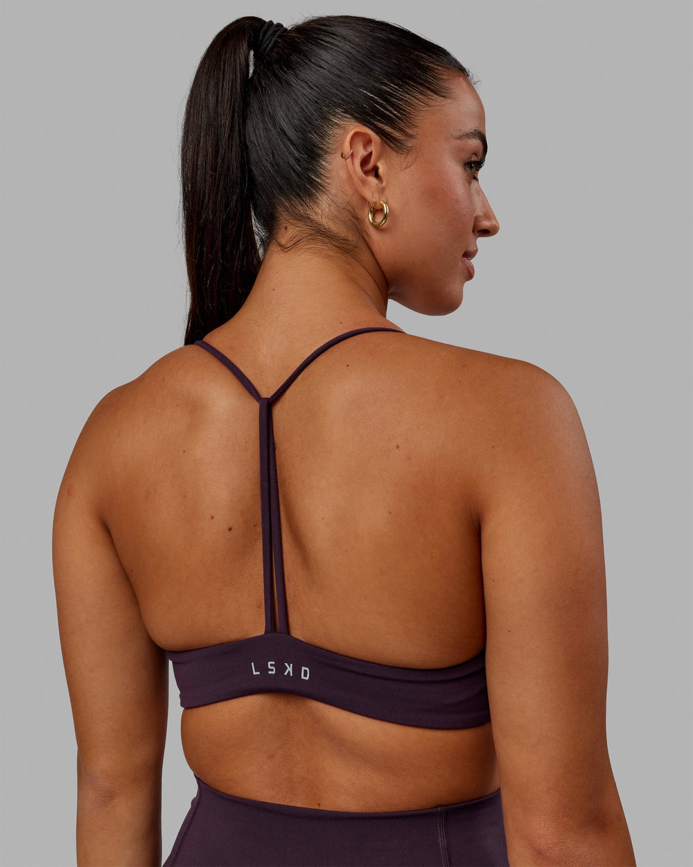 Woman wearing Progression Sports Bra - Midnight Plum