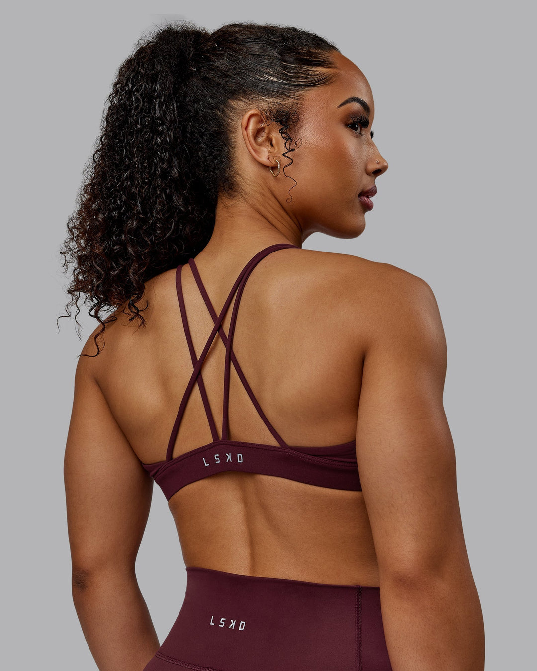 Woman wearing Pursue Sports Bra - Dark Cherry