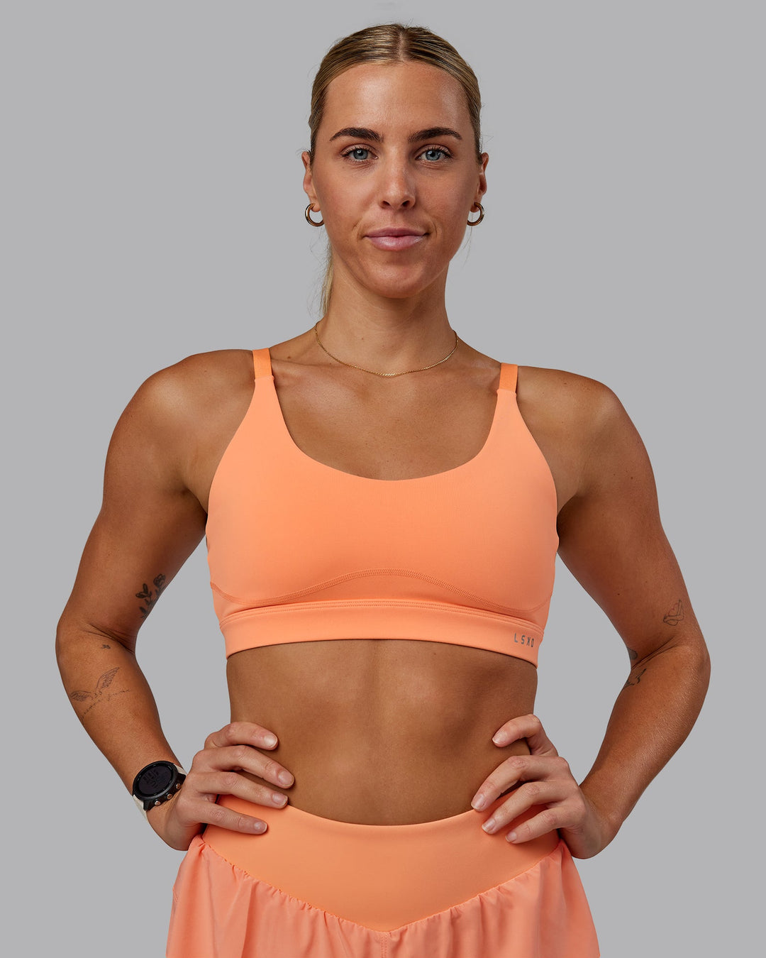 Woman wearing Rapid Sports Bra - Cantaloupe