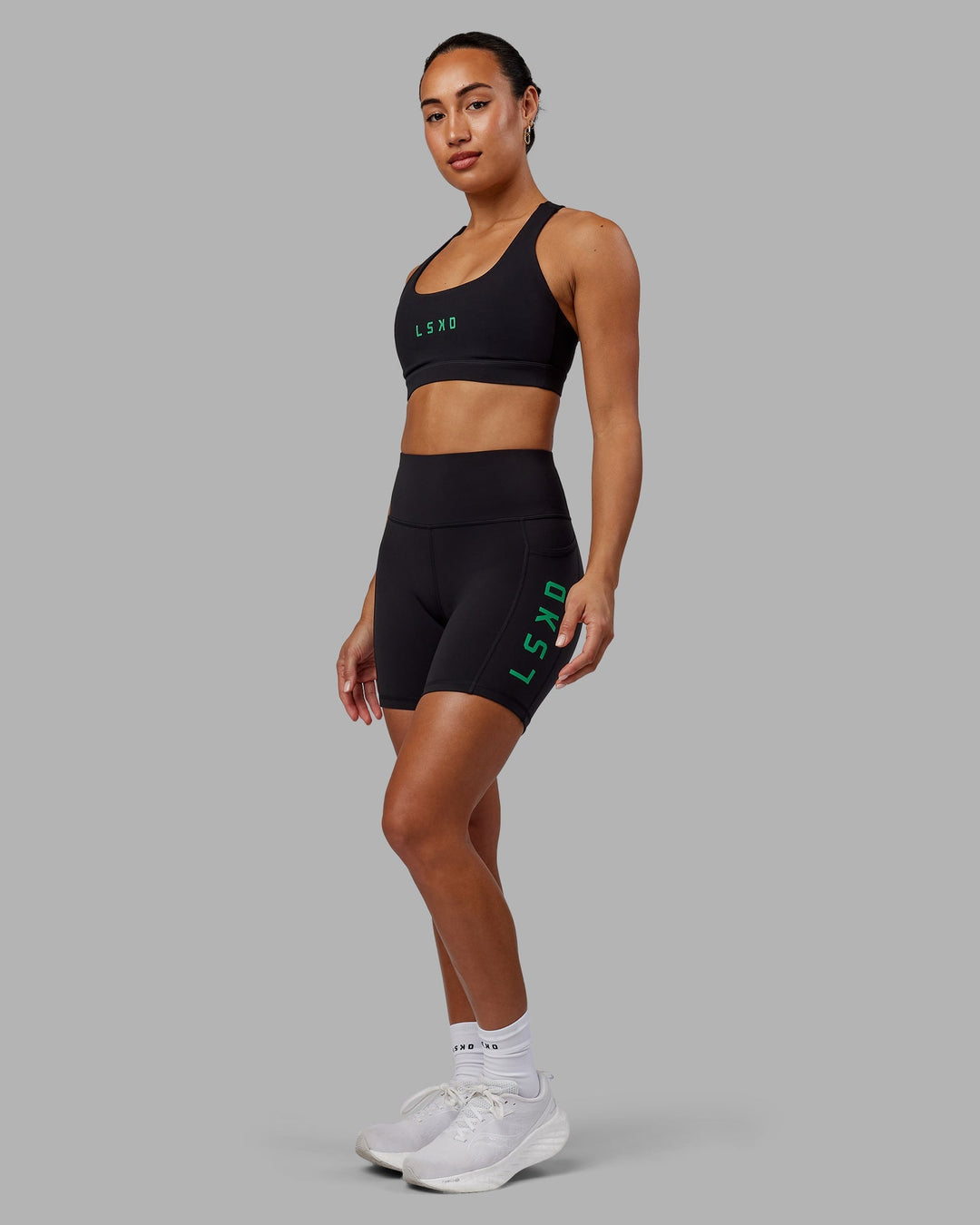 Woman wearing Rep Mid-Length Shorts - Black-Impact Green